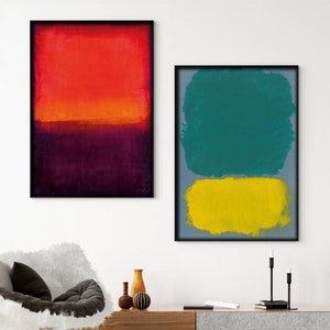 Peut inclure: Deux peintures abstraites dans des cadres noirs. La peinture de gauche est un motif abstrait rouge, orange et violet. La peinture de droite est un motif abstrait turquoise et jaune.