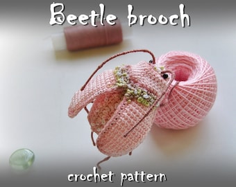 Könnte beinhalten: Ein Häkelmuster für eine rosa Käferbrosche. Das Muster enthält Anleitungen zum Häkeln des Käferkörpers, der Beine und der Fühler.