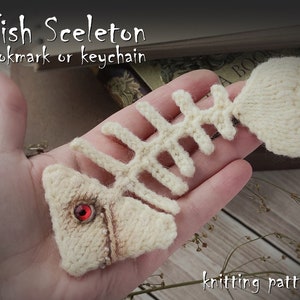 May include: A knitted white fish skeleton bookmark or keychain with a red eye. The knitting pattern is included.