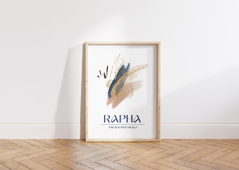 May include: A framed art print with abstract brushstrokes in navy blue, gold, and tan. The word "RAPHA" is printed in navy blue, with "THE GOD WHO HEALS" below it. The frame is light wood.