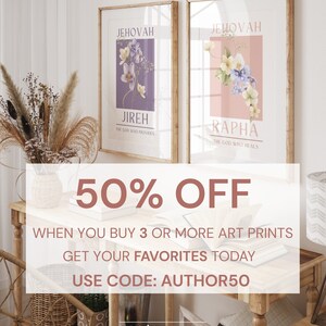 May include: Two framed art prints with floral designs. One print features a purple background with the text "JEHOVAH JIREH THE GOD WHO PROVIDES." The other print has a pink background with the text "JEHOVAH RAPHA THE GOD WHO HEALS." The prints are displayed on a wooden table.