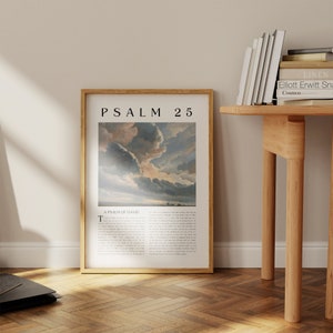 May include: A framed print with a gold frame and a white background. The print features a painting of a cloudy sky with a sunset in the distance. The text "PSALM 25" is printed in black at the top of the print. The text "A PSALM OF DAVID" is printed in black below the painting.