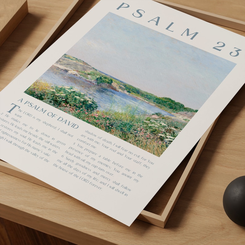 May include: A framed print featuring Psalm 23, with text and a landscape painting of a river and green banks. The print is displayed on a wooden tray. The text is in a serif font and the painting has soft colors.