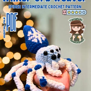 May include: A crocheted spider toy with a blue and white color scheme. The spider has eight legs and a large, round body. The spider is holding a small, white orb in its front legs. The toy is made with a soft, fuzzy yarn. The image includes the text "Winter Orb Weaver" and "Spider Intermediate Crochet Pattern".
