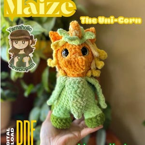 May include: A crochet pattern for a corn-themed unicorn amigurumi toy. The pattern is called "Maize: The Uni-Corn" and is described as an advanced beginner crochet pattern. The toy is green and orange with a yellow mane.
