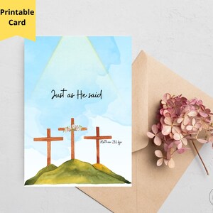 May include: A rectangular greeting card featuring a watercolor illustration of three wooden crosses on a green hill against a light blue sky. The text "Just as He said" is centered above the crosses, with "Matthew 28:6 KJV" written to the right.