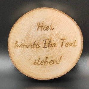 Op de afbeelding: Een ronde houten schijf met de tekst "Hier könnte Ihr Text stehen!" erop gegraveerd.