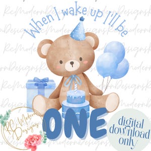 May include: A watercolour illustration for a first birthday. A brown teddy bear wears a blue party hat and sits with a blue cake, balloons, and a gift. The word "ONE" is in large blue letters, with the text "When I wake up I'll be" above the bear.