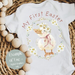May include: White baby onesie with the text "My First Easter" in brown lettering. A watercolor illustration of a duck wearing a daisy flower crown is centered on the onesie.