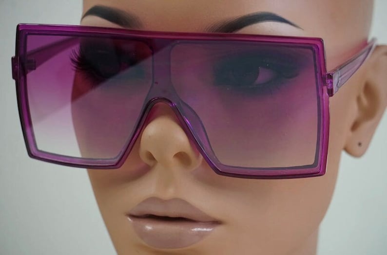 May include: Purple square-shaped sunglasses with a gradient lens. The sunglasses are on a mannequin head.