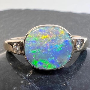 Solid Lightning Ridge Australia opal and diamond statement ring in 14k yellow gold. Gorgeous play of color in this stunning opal ring!