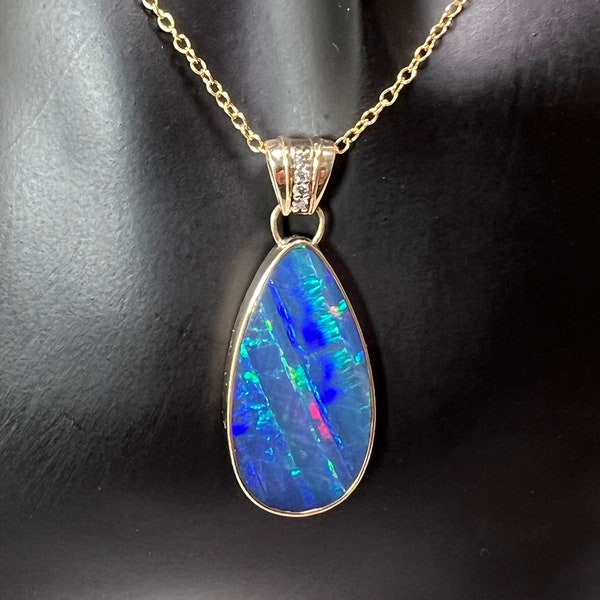 Stunning royal blue with multicolor flash teardrop Australian opal pendant set in 14K yellow gold with diamond accented bail.