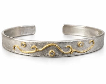 Mixed metals sterling silver and 22K yellow gold cuff bracelet with accent diamonds.