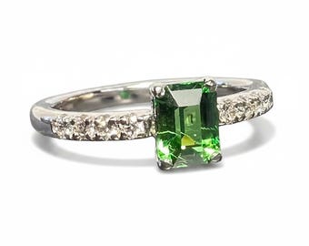 Emerald cut tsavorite garnet ring with diamond accented band set in 14k white gold.