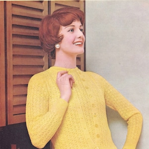 Puede incluir: Un cárdigan de punto amarillo con cierre de botones y un delicado patrón de calado. El cárdigan lo lleva una mujer con el pelo rojo corto.