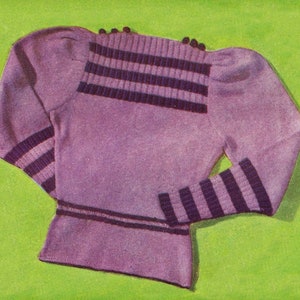 Puede incluir: Un suéter morado con rayas negras en las mangas y el cuello. El suéter tiene un diseño de hombro abullonado.