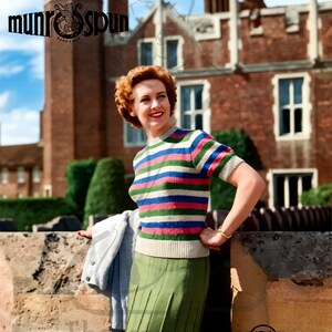 May include: A woman wearing a striped short-sleeve sweater with green, pink, blue, and white stripes, paired with a pleated green skirt. The image includes the text "munrospun" and "Number 11". The background features a brick building and a blue sky.