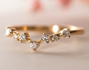 May include: A delicate gold ring with a curved design featuring a row of small, sparkling diamonds.