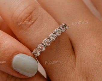 May include: A silver band ring with a row of small, round, clear diamonds.