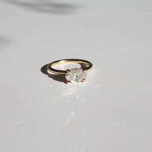 May include: A gold ring with an oval-shaped diamond set in a simple band.
