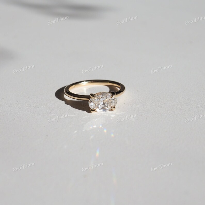 May include: A gold ring with an oval-shaped diamond set in a simple band.