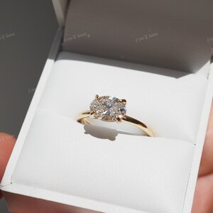 May include: A gold engagement ring with a large oval-shaped diamond surrounded by smaller diamonds.