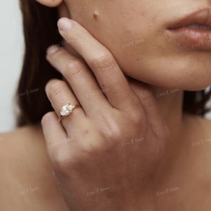 May include: A gold ring with a large oval-shaped diamond set in a simple band.
