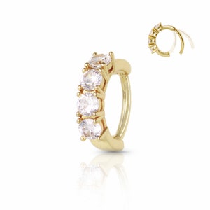 Könnte beinhalten: Goldener Creolenohrring mit fünf klaren Zirkonia-Steinen in einer Reihe.