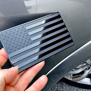 Emblema de bandera de EE. UU. de metal negro para autos y camiones, 12,7 x 7,6 cm, 1 unidad