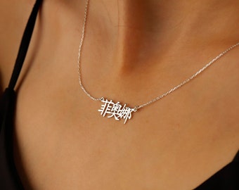 Peut inclure: Un collier en argent avec une chaîne délicate et un pendentif représentant les caractères chinois pour "Rêve".