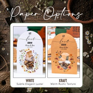 May include: Two arched seed packets with a cutout window showing seeds. The white packet features colorful floral illustrations and the text "LET love GROW Alena & Ben 4.26.2025". The kraft packet features similar floral art and "LET love GROW Alena & Ben 4.22.2025".