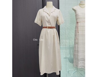 May include: A white and cream striped midi dress with a brown belt. The dress has a collared neckline and short sleeves.