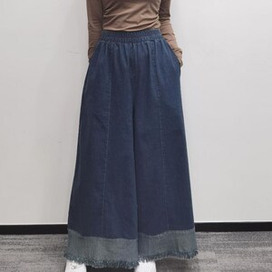 May include: Wide-leg denim pants with a frayed hem and a dark blue wash.