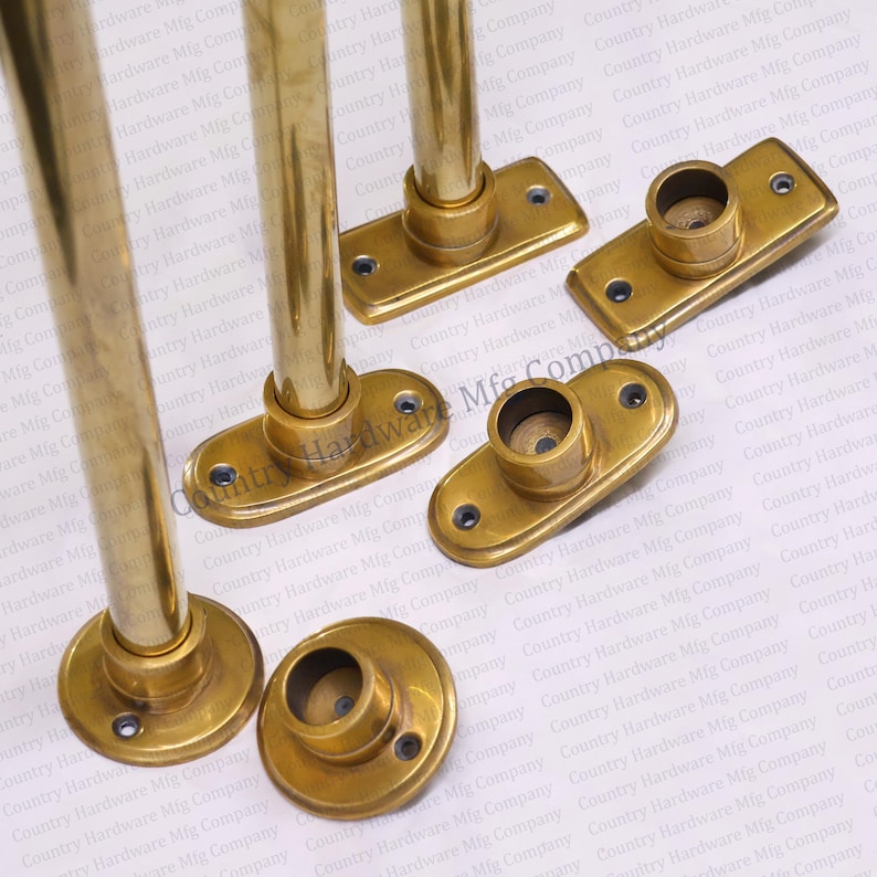 May include: Four brass curtain rod finials with oval-shaped bases. The finials have a smooth, polished finish and are designed to be used with a curtain rod.
