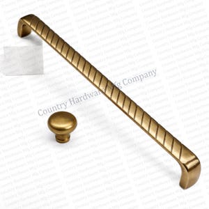 May include: Antique brass finish cabinet hardware set. Includes a long pull handle with a diagonal grooved design and a round knob. Perfect for kitchen or bathroom cabinets. The hardware is made of metal.