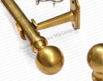 May include: A set of brass-colored curtain rods, brackets, and finials. The rods are cylindrical, and the finials are spherical. The brackets are designed to mount the rods to a wall. The hardware is made of metal.