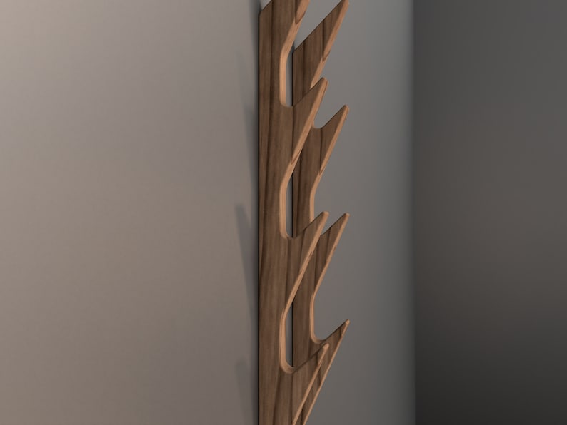 May include: A wooden wall-mounted coat rack with five hooks shaped like stylized leaves. The rack is made of dark wood with a natural grain pattern.