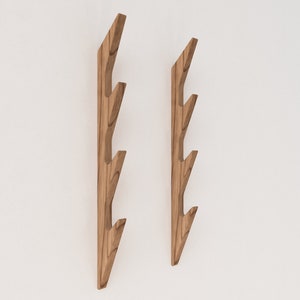 May include: Two wooden wall hooks with a branch-like design. Each hook has four branches that curve upwards, creating a unique and modern look.