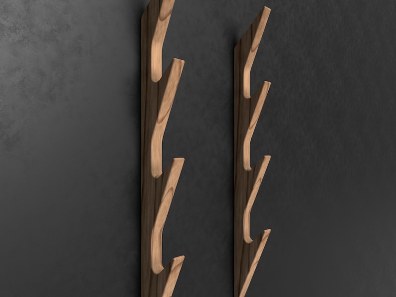 May include: Two wooden wall mounted coat racks with five hooks each. The hooks are curved and angled to create a unique design. The racks are made of natural wood with a light brown finish.
