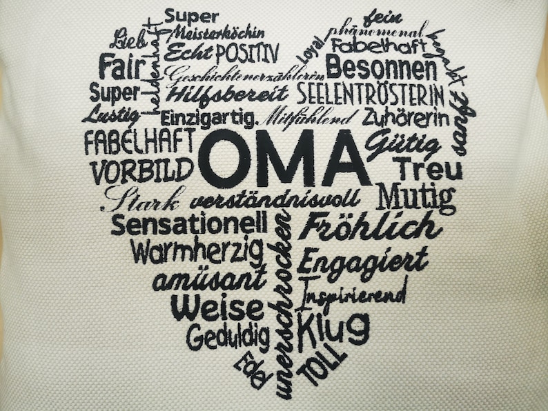 May include: A heart-shaped word cloud with the word "OMA" in the center. The word cloud is made up of positive adjectives in German, such as "hilfsbereit", "treu", and "fr&ouml;hlich".