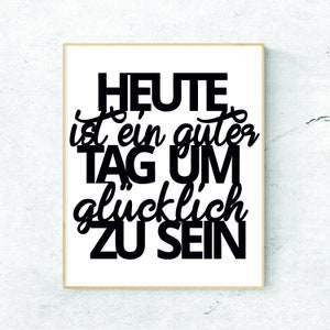 May include: Black and white typography print with the text "HEUTE ist ein guter TAG UM glücklich ZU SEIN" on a white background with a light brown frame.