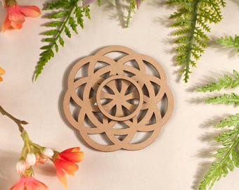 Könnte beinhalten: Ein Untersetzer aus Holz mit einem geometrischen Design, das einen Kreis in einem Kreis zeigt. Der Untersetzer ist braun und hat eine natürliche Holzoptik.