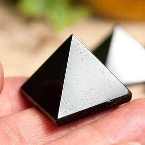 Può includere: Una piramide di cristallo di ossidiana nera, una scelta popolare per la meditazione e il lavoro energetico.