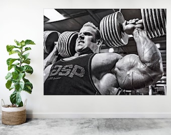 May include: A black and white photo of a muscular man lifting heavy dumbbells in a gym. He is wearing a black tank top with the word "GSP" printed on it.