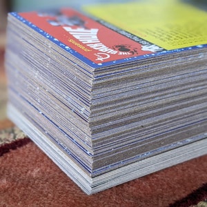 May include: A stack of trading cards featuring a blue and red design with the text "The Black Hole Presents" and a graphic of a black hole.