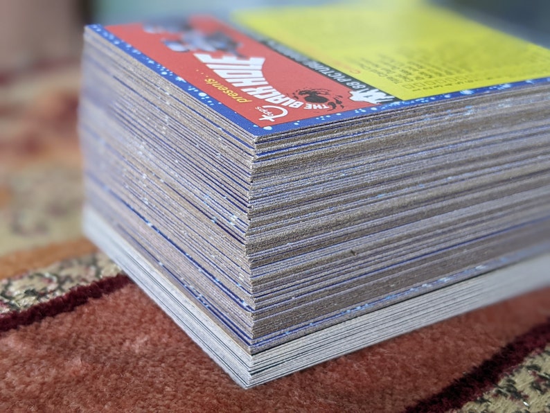 May include: A stack of trading cards featuring a blue and red design with the text "The Black Hole Presents" and a graphic of a black hole.