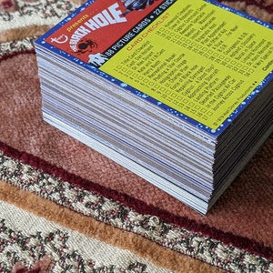 May include: A stack of 88 trading cards featuring characters and scenes from the 1979 film "The Black Hole". The cards are blue, yellow, and white with a checklist on the back.