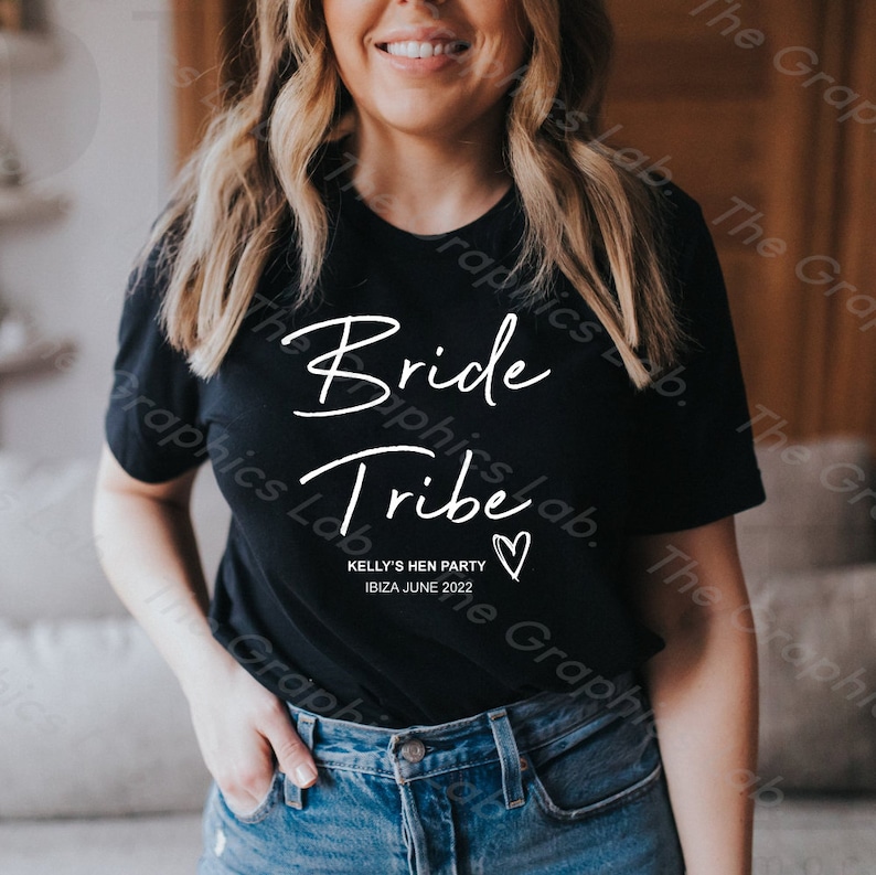 May include: Black t-shirt with white text that says "Bride Tribe" and "Kelly's Hen Party Ibiza June 2022" with a white heart.