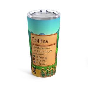 Może przedstawiać: Kubek ze stali nierdzewnej z pikselowym wzorem ziarna kawy i sceny farmy z gry wideo Stardew Valley. Tekst na kubku brzmi "Coffee" i "It smells delicious. This is sure to give you a boost. +3 Energy +1 Health +1 Speed".