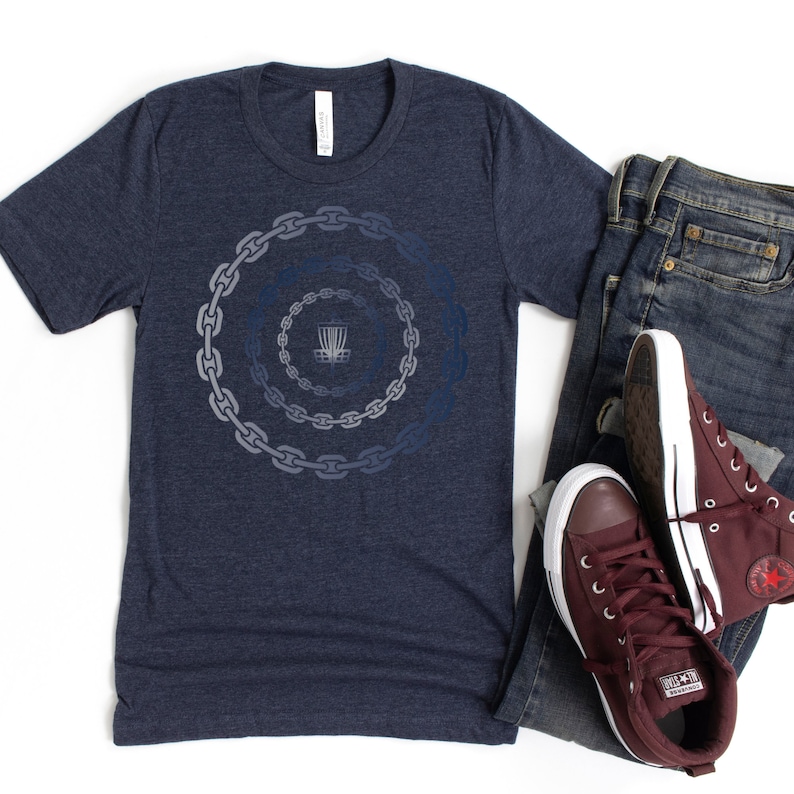 K&ouml;nnte beinhalten: Ein marineblaues T-Shirt mit einem Motiv einer Discgolf-Scheibe in einem Ketten-Design.